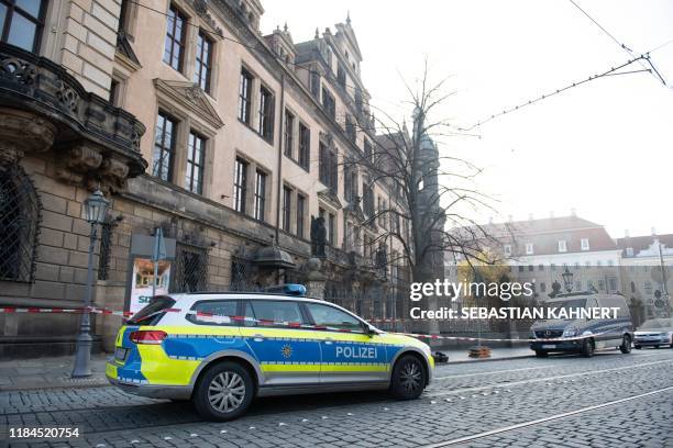 Police car stands in front of the cordoned off Royal Palace that houses the historic Green Vault in Dresden, eastern Germany on November 25 after it...