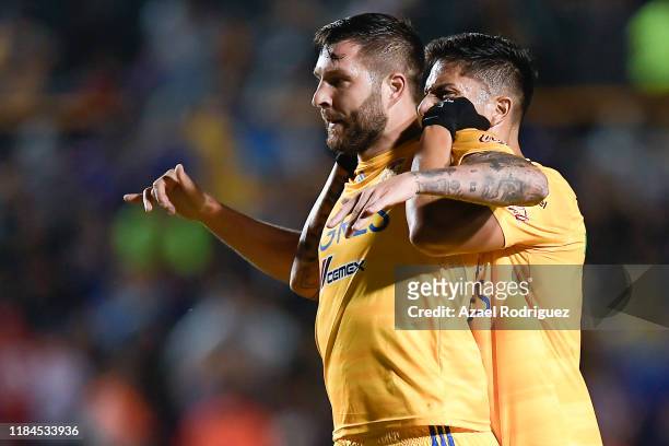 Andre-Pierre Gignac, #10 of Tigres, celebrates with teammate Carlos Salcedo, #3, after scoring his team's first goal during the 16th round match...