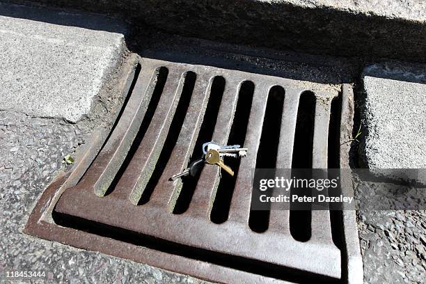 keys tumbling into drain - key drop stock pictures, royalty-free photos & images
