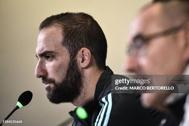 Juventus' Argentinian forward Gonzalo Higuain and Juventus' Italian coach Maurizio Sarri speak during a press conference on November 25, 2019 at the...
