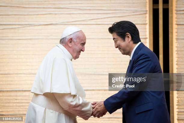 Pope Francis shakes hands with Japan's Prime Minister Shinzo Abe during a meeting with the diplomatic community at the prime minister's office on...