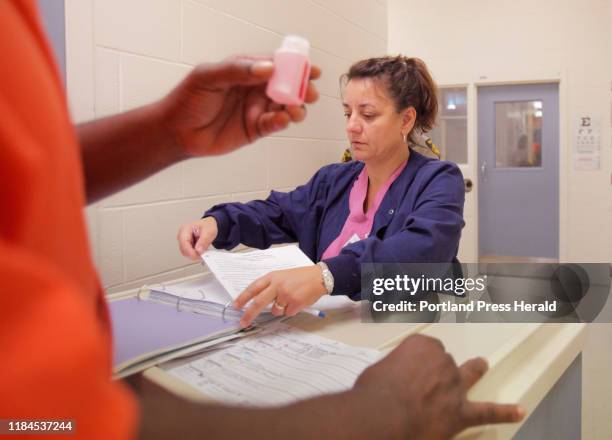 Carmen Mulholland, a nurse with Allied Resources, dispenses methadone to an inmate at the Penobscot County Jail in Bangor on Thursday, September 15,...