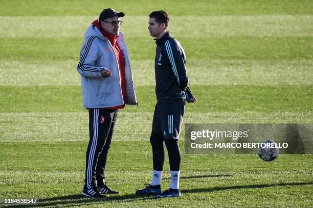 Juventus' Italian coach Maurizio Sarri talks to Juventus' Portuguese forward Cristiano Ronaldo on November 25, 2019 during a training session at the...