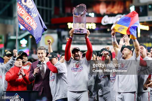 Manager Dave Martinez of the Washington Nationals hoists the Commissioners Trophy after defeating the Houston Astros 6-2 in Game Seven to win the...