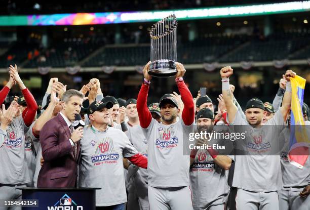 Manager Dave Martinez of the Washington Nationals hoists the Commissioners Trophy after defeating the Houston Astros 6-2 in Game Seven to win the...