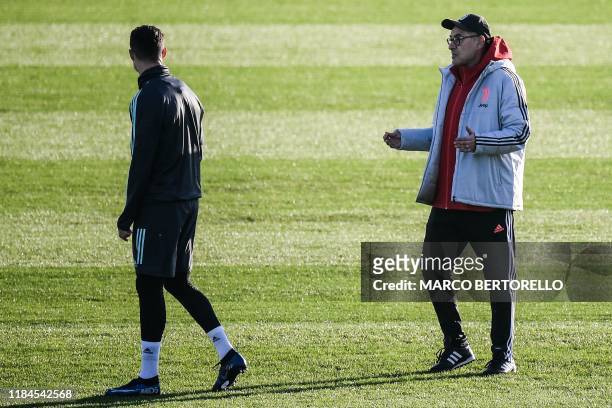 Juventus' Italian coach Maurizio Sarri talks to Juventus' Portuguese forward Cristiano Ronaldo on November 25, 2019 at the Continassa Training Ground...