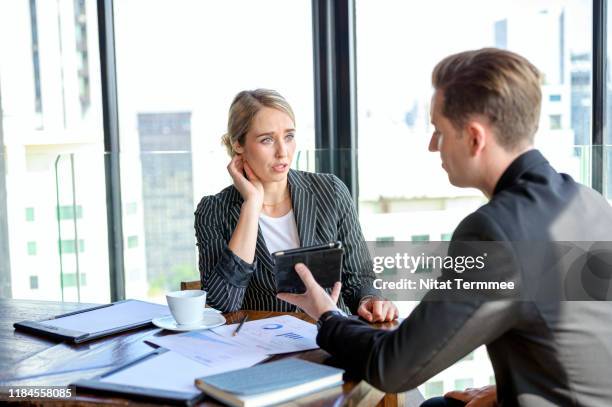 two confident business people using a digital tablet together. businessman reporting company financial report to female managing directors. - 担当責任者 ストックフォトと画像