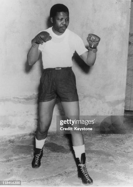 Nelson Mandela, leader of the African National Congress , adopts a boxing pose, wearing shorts, t-shirt and boxing gloves, circa 1950.