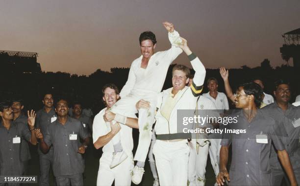 Australia captain Allan Border is hoisted high by team mates Dean Jones and Tom Moody as local security guards follow round after Australia had...