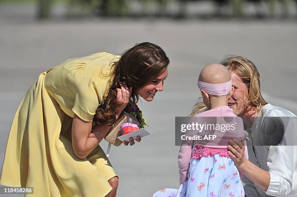 Catherine, the Duchess of Cambridge, receives a gift from, 6-year-old Diamond Marshall and her mother, Mrs. Danielle Marshall, at Calgary...