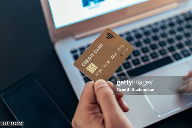 paying with credit card - hand holding credit card stock pictures, royalty-free photos & images