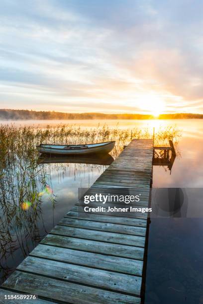 boat in lake at sunrise - riet stockfoto's en -beelden