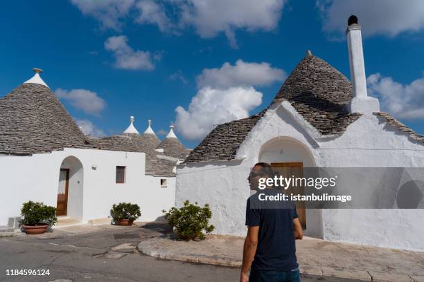 touristes dans les rues traditionnelles d'alberobello - trulli photos et images de collection