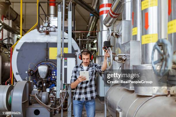 technicien vérifiant le système - boiler repair photos et images de collection