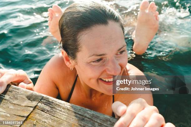 happy woman in sea - bathing in sunset stockfoto's en -beelden