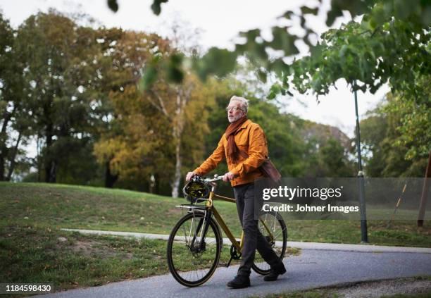 man pushing bicycle - homem 55 anos imagens e fotografias de stock