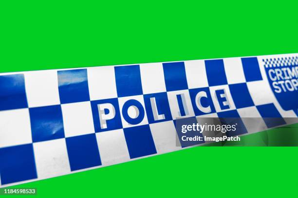 australian police tape on a green screen background - police tape australia stock-fotos und bilder