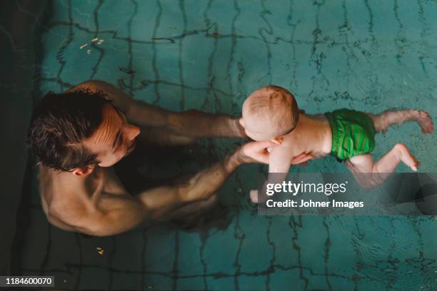 father with baby in swimming-pool - baby swimmer stock pictures, royalty-free photos & images