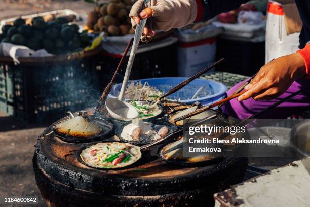 cooking a banh xeo at a street market, vietnam - vietnamese pancake stock pictures, royalty-free photos & images