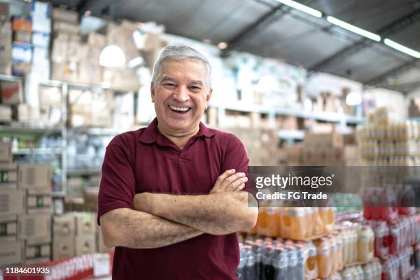 porträt eines glücklichen besitzer senior im großhandel - tante emma laden stock-fotos und bilder