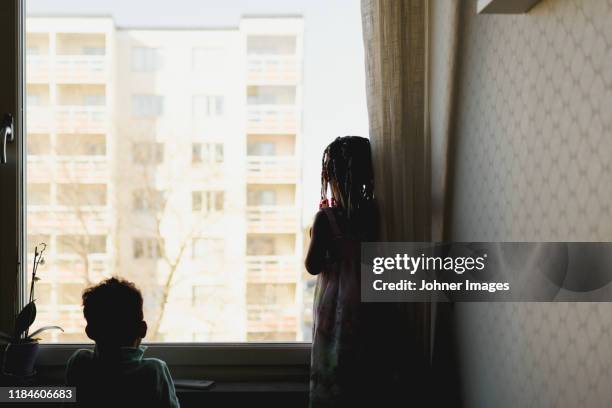 girl looking through window - family silhouette generations stock pictures, royalty-free photos & images