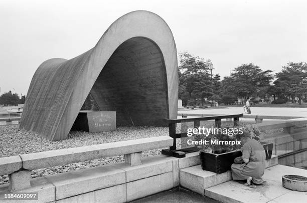 Peace Memorial Park, Hiroshima, Japan, August 1967; pictured: relative of Hiroshima bomb victim kneels in prayer at the shrine where the ashes of...