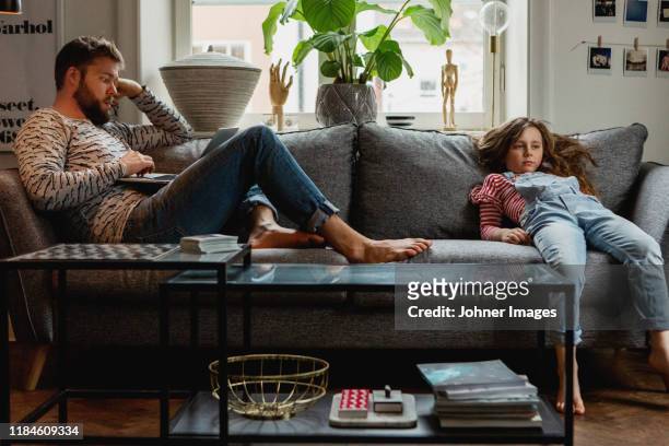 father and daughter on sofa - bores stock pictures, royalty-free photos & images