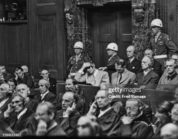 Nazi defendant Hermann Goering in the dock behind the defence counsel, under guard in Room 600 at the Palace of Justice in Nuremberg during legal...