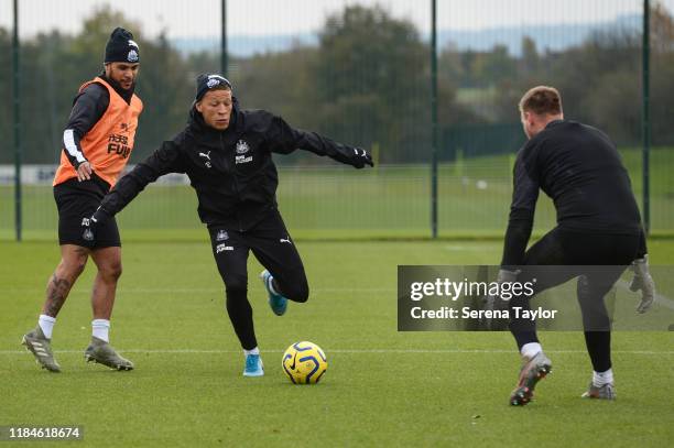 Dwight Gayle looks to strike the ball as he passes DeAndre Yedlin and into the line of Goalkeeper Rob Elliot during the Newcastle United Training...