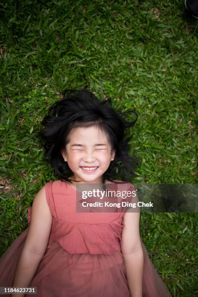 girl lie down on grass - girl lying down stock pictures, royalty-free photos & images