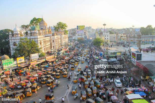 The traffic around charminar market with auo rickshaws and cars moving in the main street, picture taken from the charminar monument