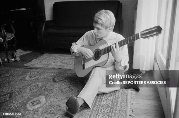 Le chanteur français Christophe joue de la guitare chez lui à Paris le 19 novembre 1963, France.
