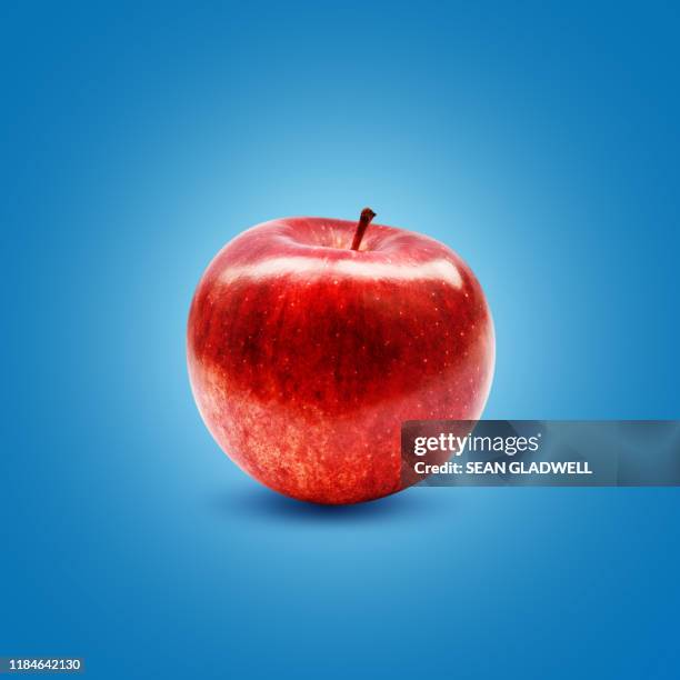 ripe red apple on blue - apple fruit stock pictures, royalty-free photos & images