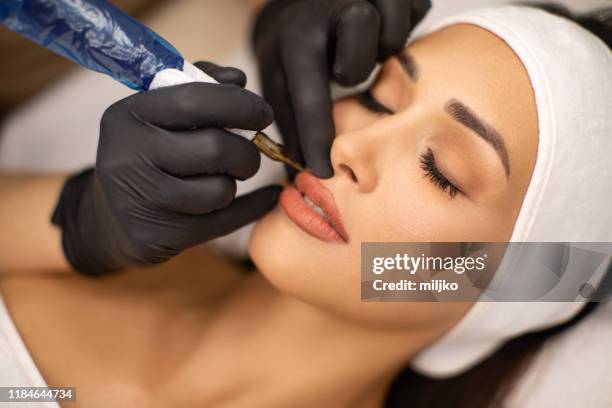 belle jeune femme recevant le maquillage permanent - micropigmentation head photos et images de collection