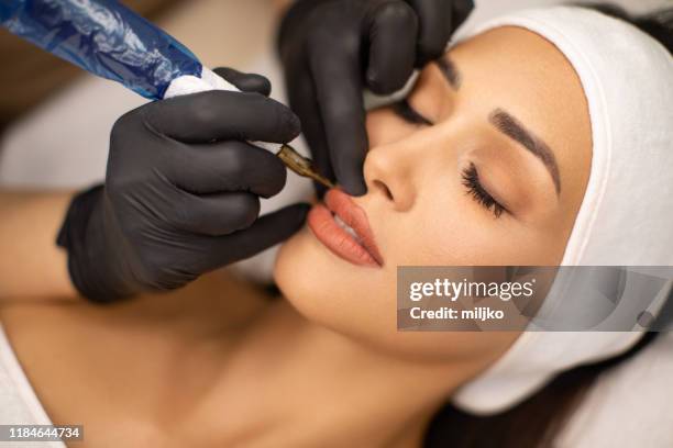 beautiful young woman receiving permanent make up - lip tattooing stock pictures, royalty-free photos & images