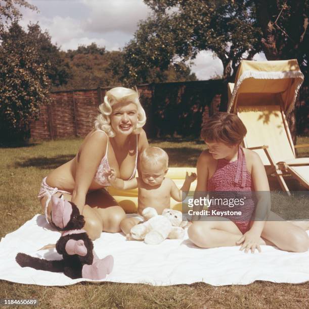American actress Jayne Mansfield in the garden with her baby son Miklos and daughter Jayne Marie, circa 1959.