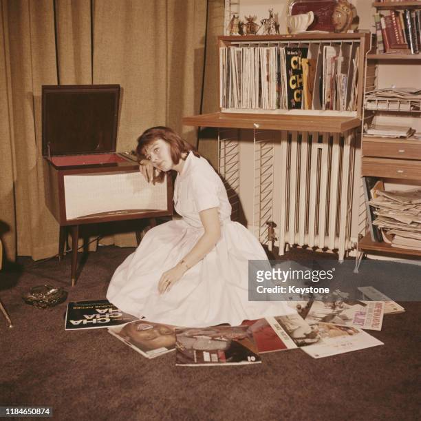 English actress Janet Munro with a pile of records, circa 1960.