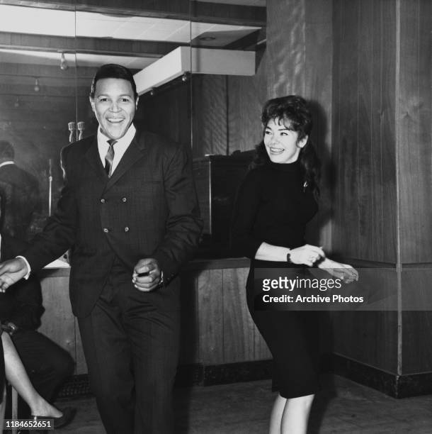 American rock 'n' roll singer and dancer Chubby Checker dancing with a young woman, circa 1968.