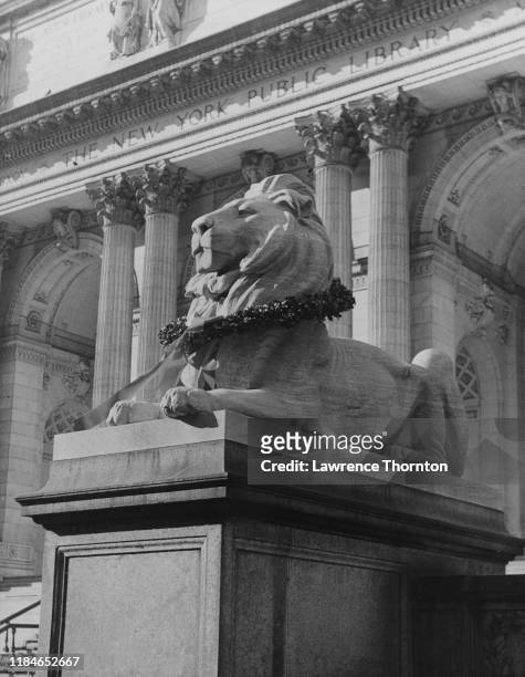 Wreath around a stone lion outside the main branch of the New York Public Library on Fifth Avenue, New York City, at Christmas, circa 1950.