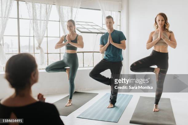 yoga instructor teaching yoga in studio - men wearing bras photos stock pictures, royalty-free photos & images