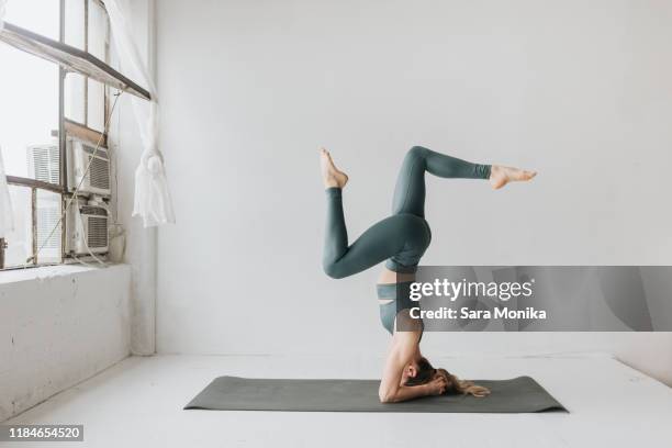 woman practising yoga in studio - goal sports equipment fotografías e imágenes de stock