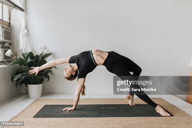 woman practising yoga in studio - yoga pose stock-fotos und bilder