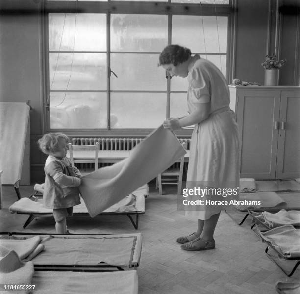 Child helping with the chores at a day nursery in the Social Centre in Slough, Berkshire, England, during World War II, November 1940.