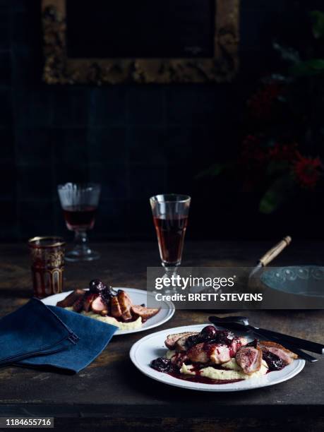 roast duck with celeriac puree cherry and pinot sauce - mesa para dos fotografías e imágenes de stock