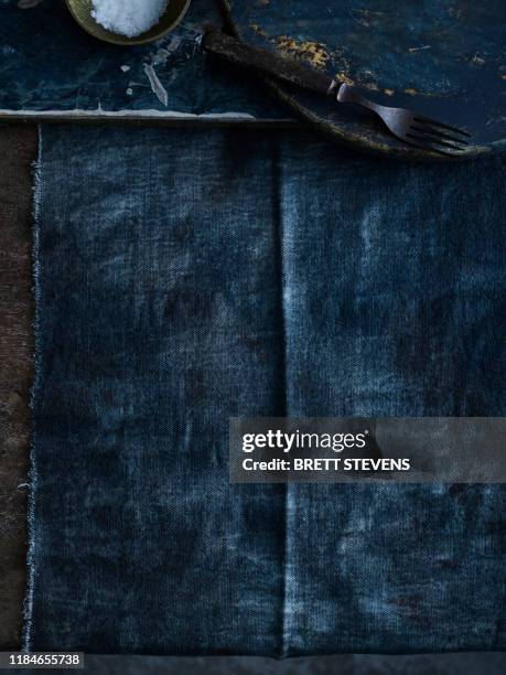 empty plate and bowl of salt on dark tablecloth - blue tablecloth stockfoto's en -beelden