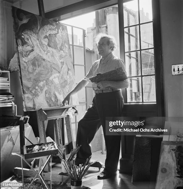 Russian-French artist Marc Chagall at work on a circus painting in his studio, circa 1942.