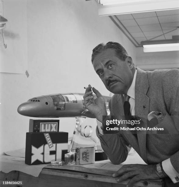 French-born American industrial designer Raymond Loewy with some of his designs, the Lux Flakes box, the packaging for Lucky Strike cigarettes and...