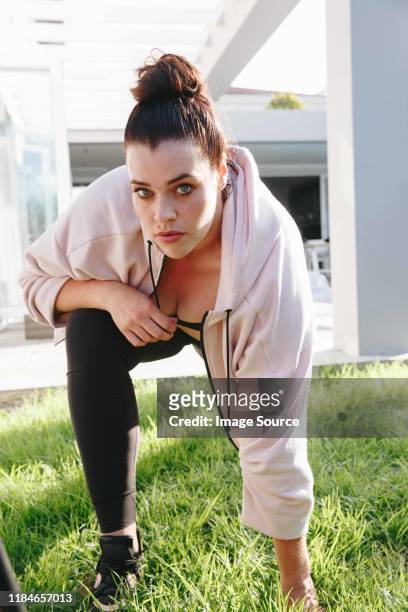 woman doing stretching exercise in garden - große brüste stock-fotos und bilder