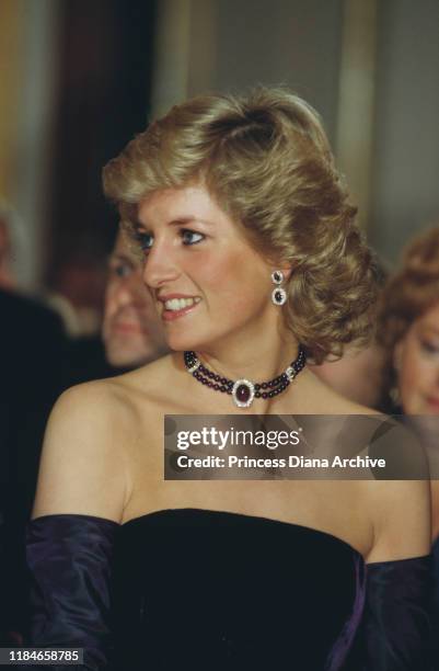Diana, Princess of Wales attends the opera in Munich, Germany, wearing a purple strapless gown by Catherine Walker, November 1987.