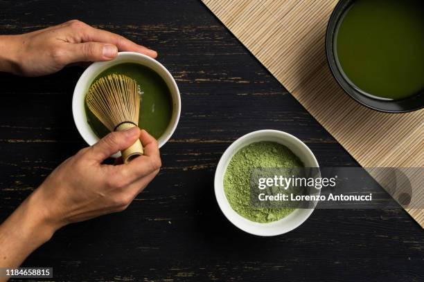 woman's hands mixing matcha green tea powder in a bowl, overhead view - matcha tea stock pictures, royalty-free photos & images
